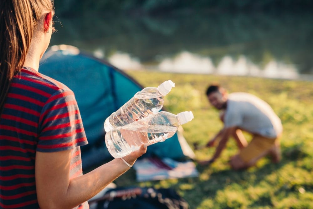 A woman carrying water bottles