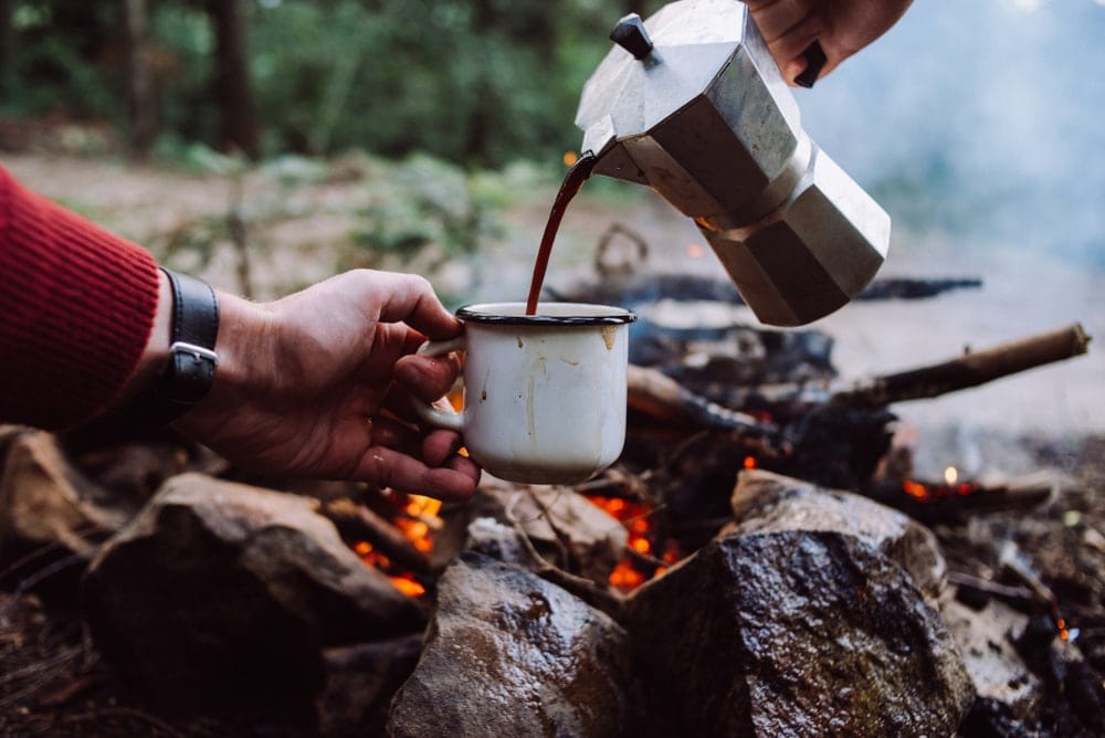 Pouring coffee into an enamel mug