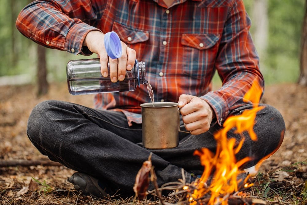 Man pouring a water in a stainless cup