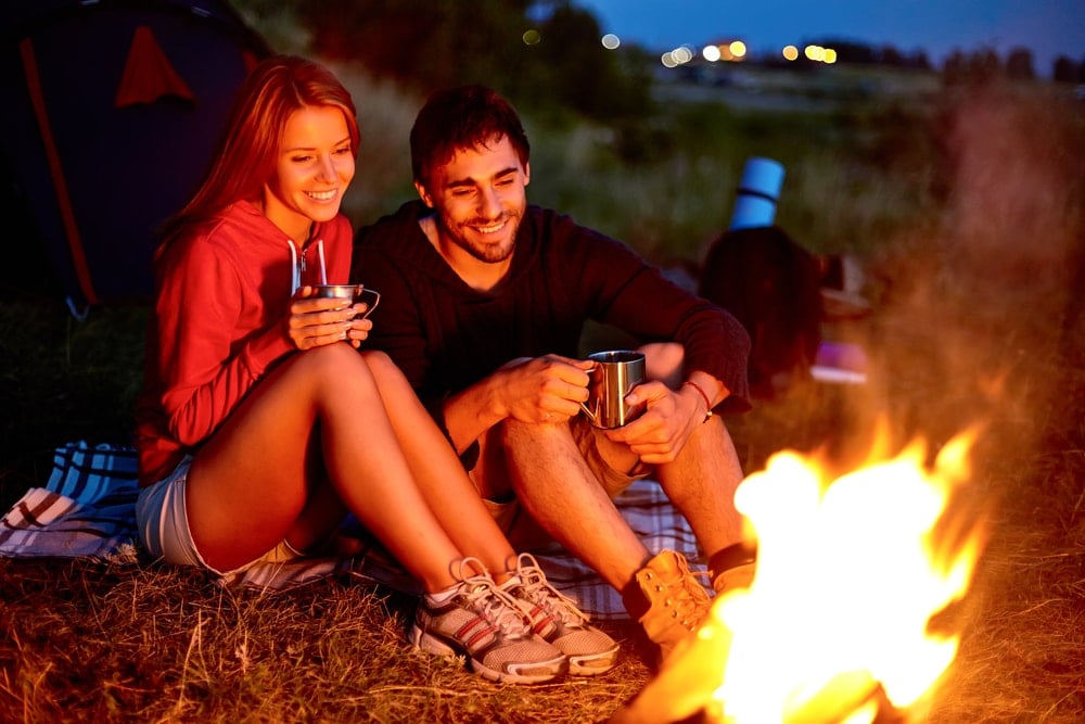 Smiling couple having a camping date