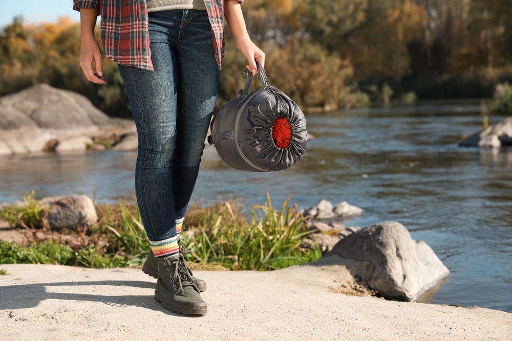 A woman carrying a tent bag