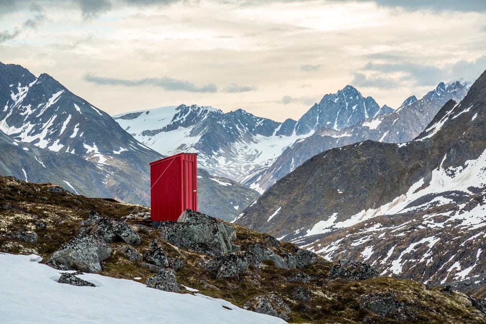 Red toilet standing in the mountains