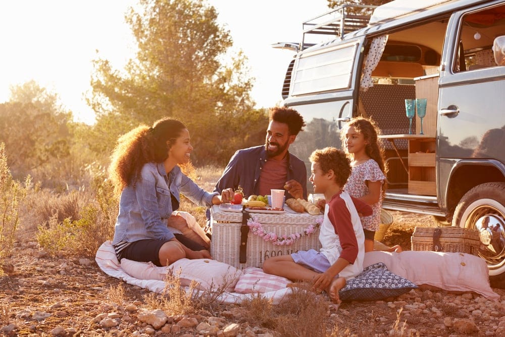 Family having picnic beside camper