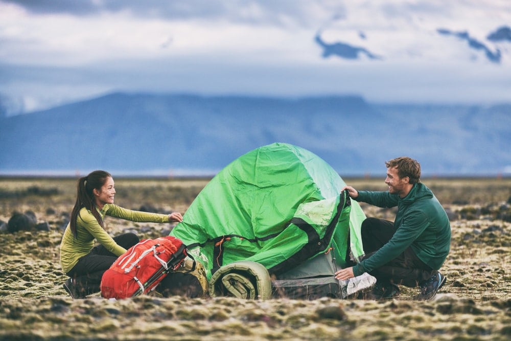 Smiling couple packing a tent