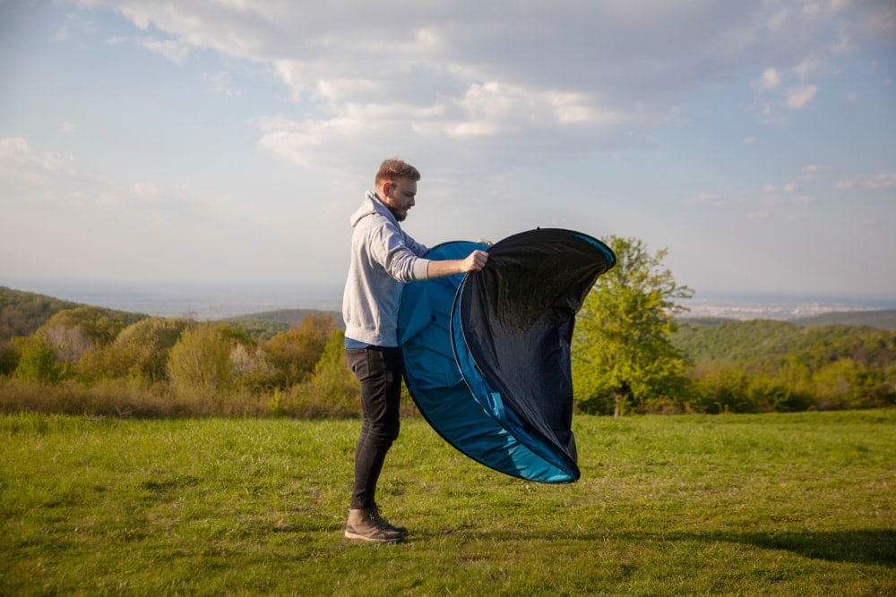 Man setting up fast pitch tent