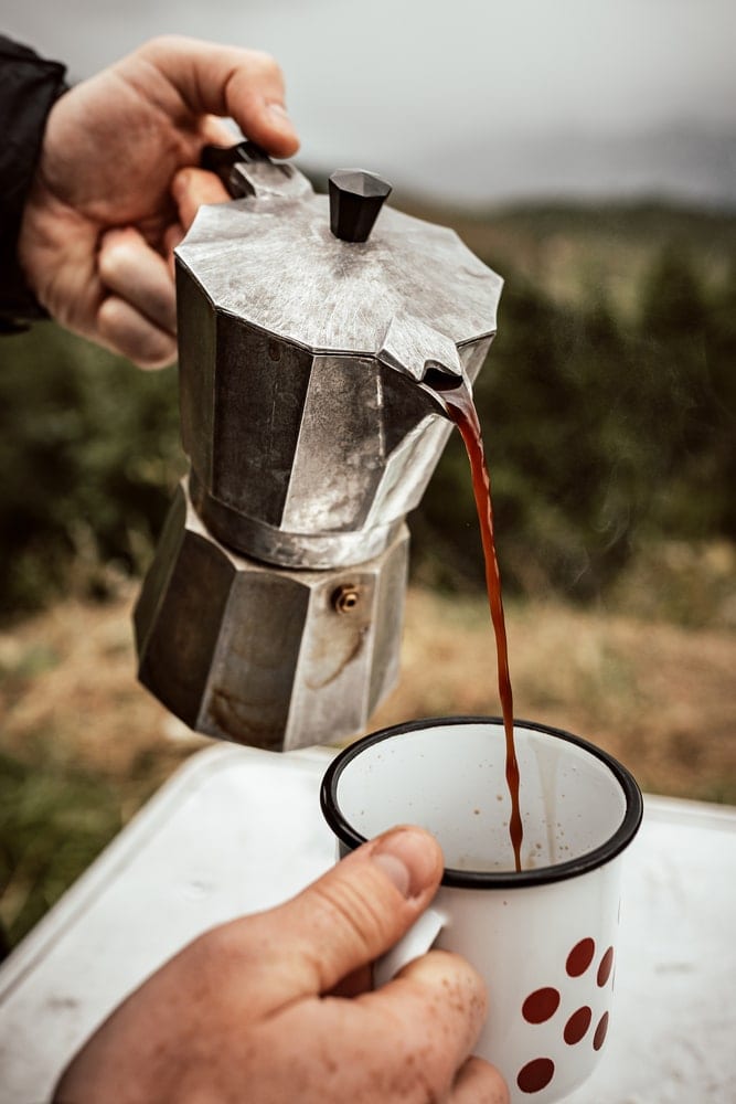 Person serving and enjoying coffee outdoors