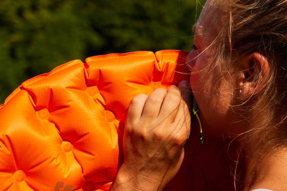 Woman inflating a sleeping bag