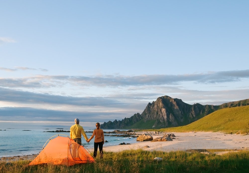 Couple holding hands while looking at the beach