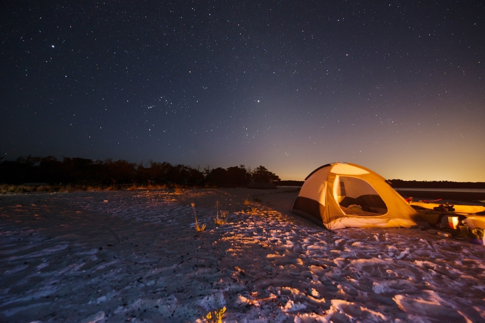 camping tent on the beach under night sky