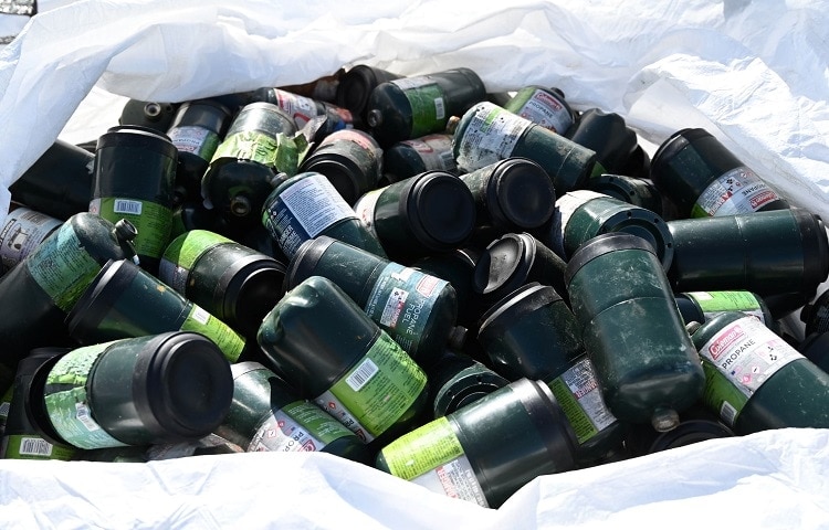 trash full of empty propane tanks