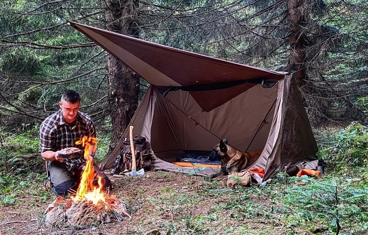 a man setting up a campfire during primitive camping 
