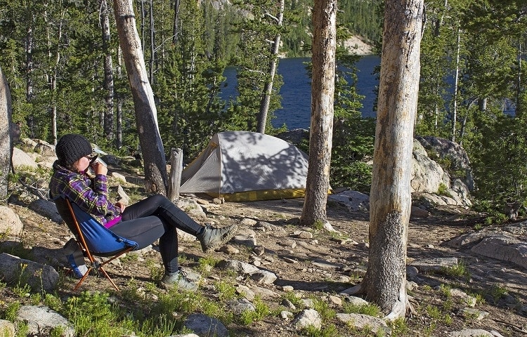 a woman enjoying a coffee while camping 