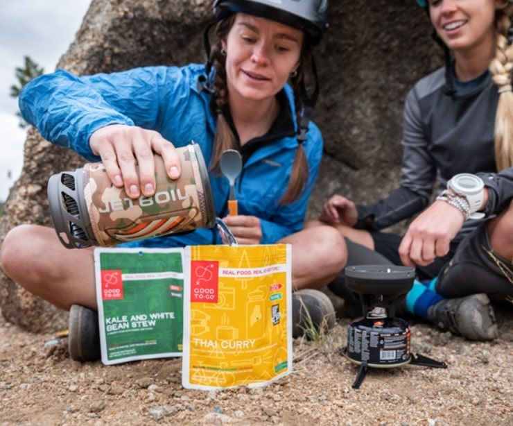 Hikers pouring a boiled water from a jetboil stove