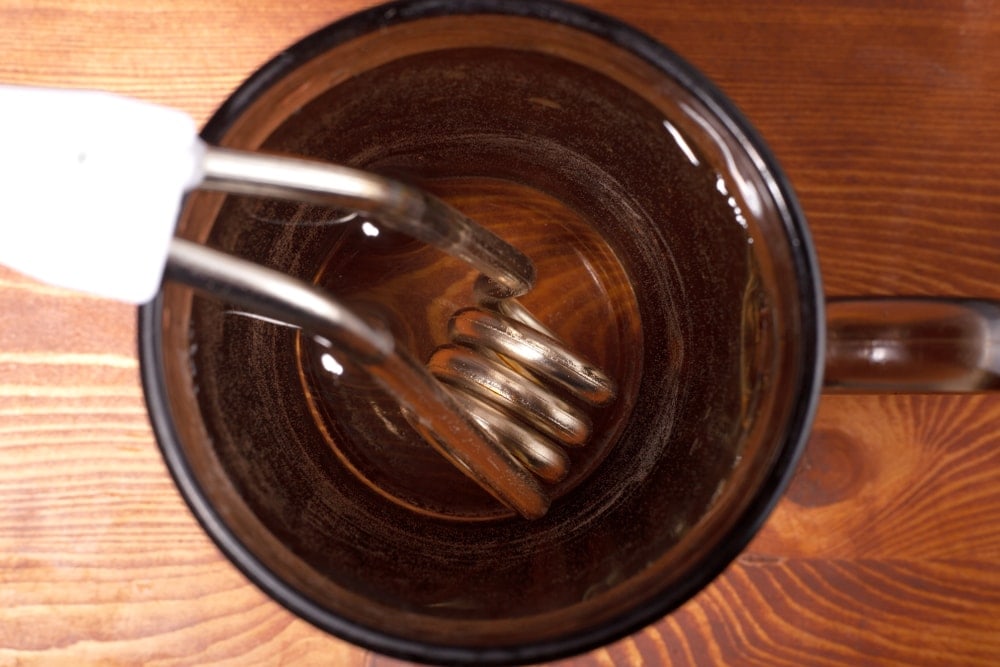 Immersion heater soaked in water to boil water while camping