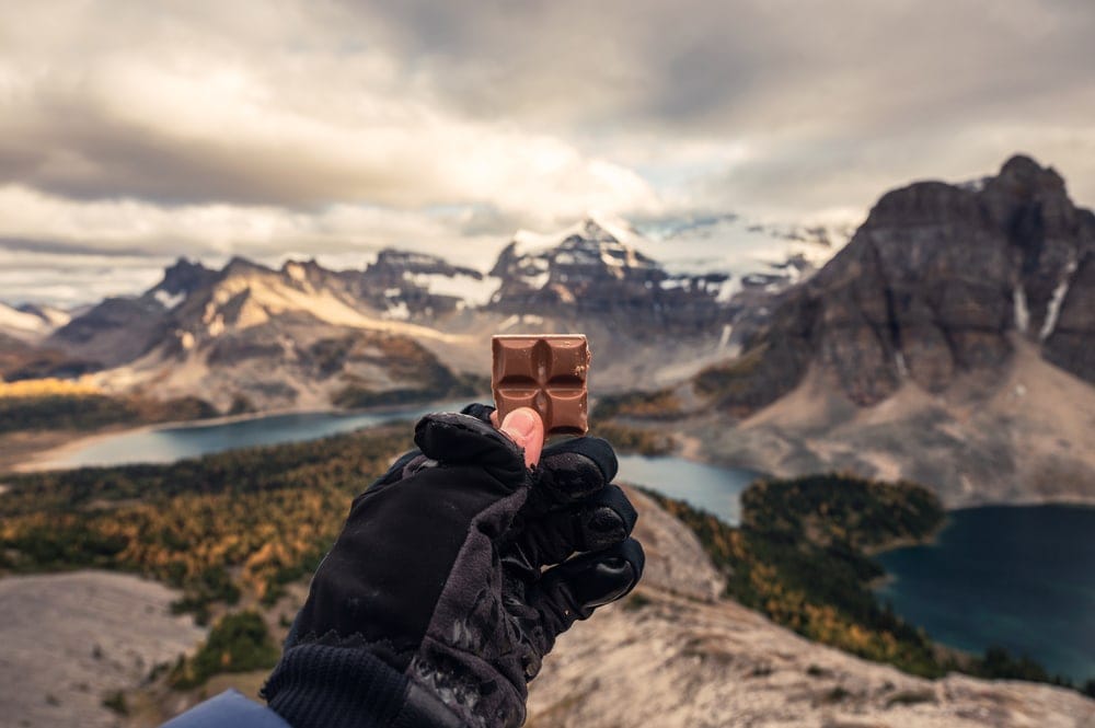 Hiker holding a chocolate bar as camping food