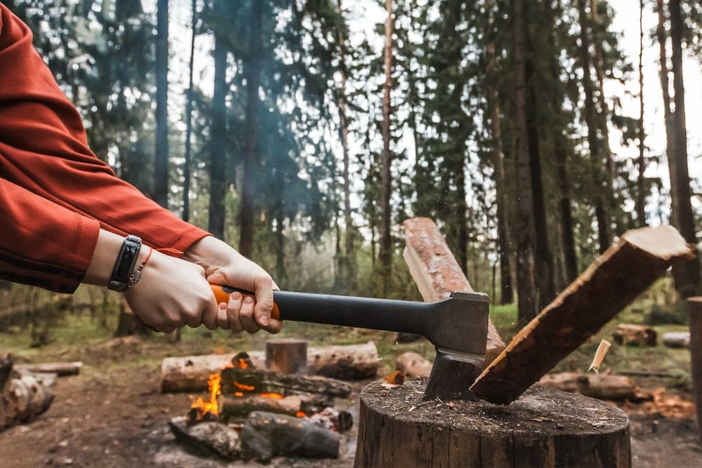 Person splitting firewood during camping