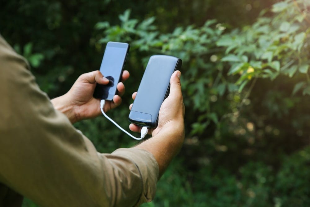 Man holding a phone and a powerbank