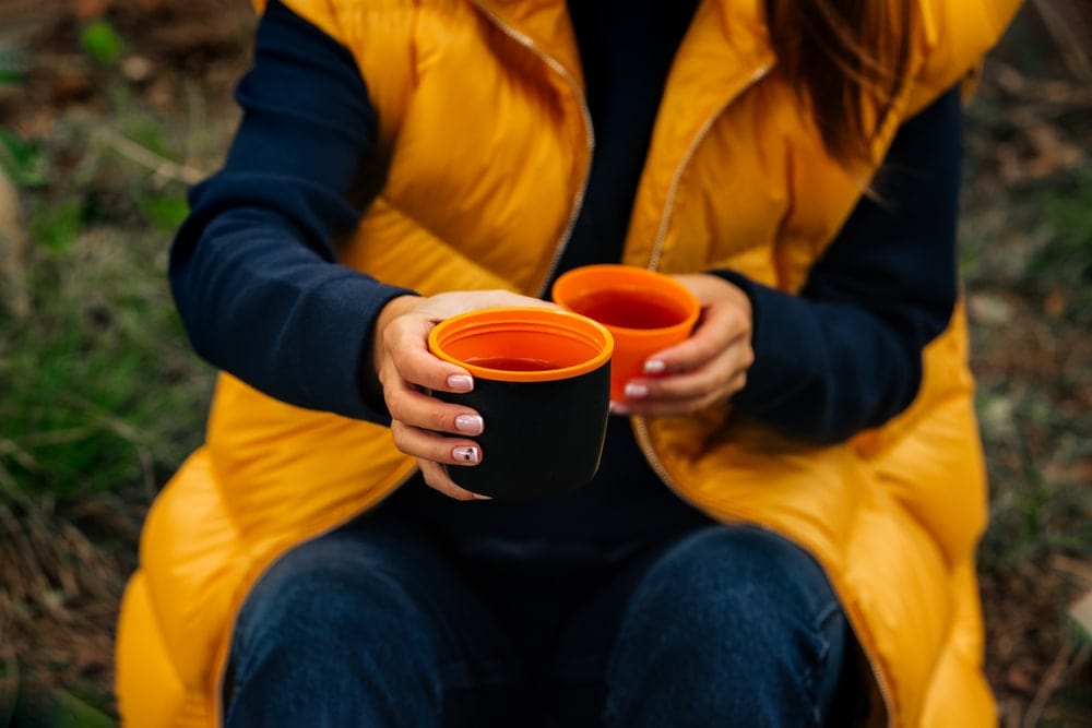 Woman holding a cup while camping