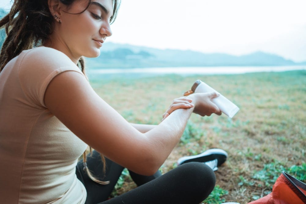 Woman putting lotion on her arms