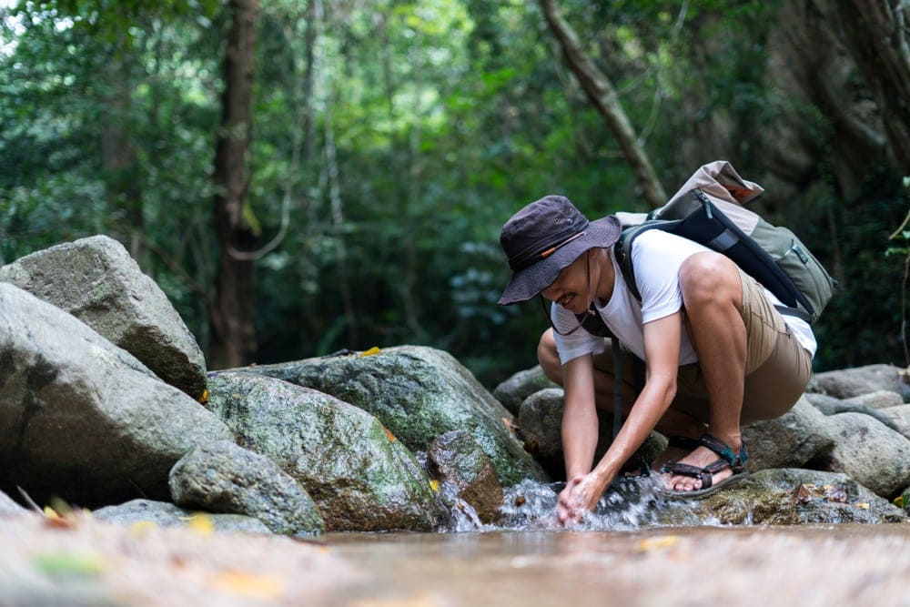 Hiker washing his hand at the river
