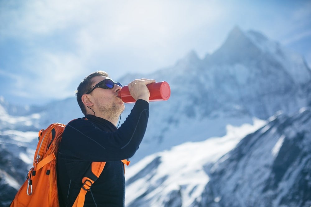 Man drinking water while hiking