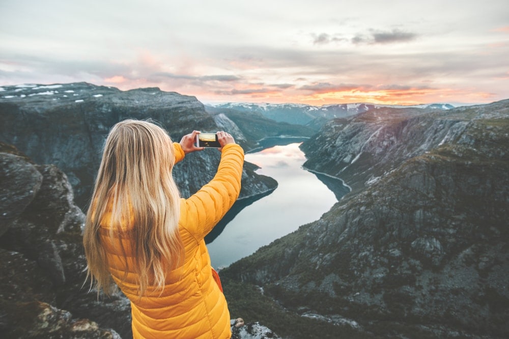 Woman taking a picture of the mountains