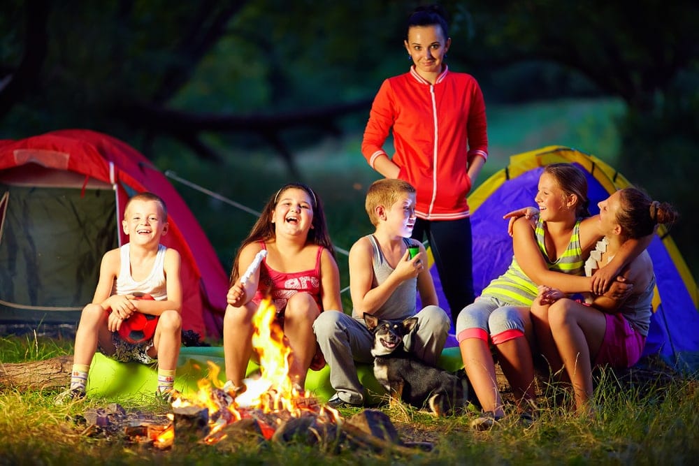 Kids laughing and talking around a campfire