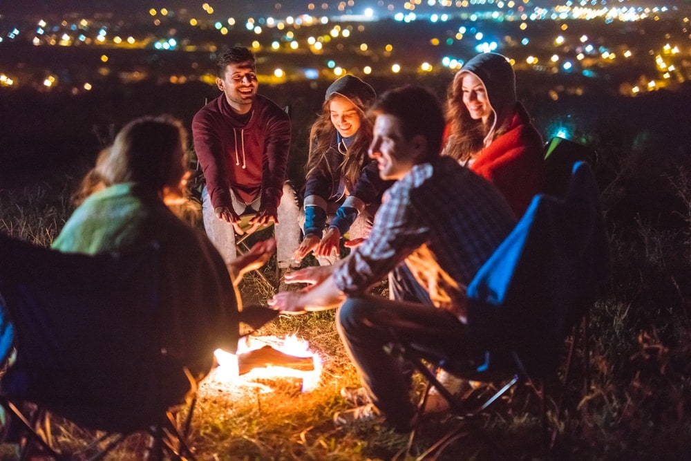 Five friends enjoying the night and playing campfire games