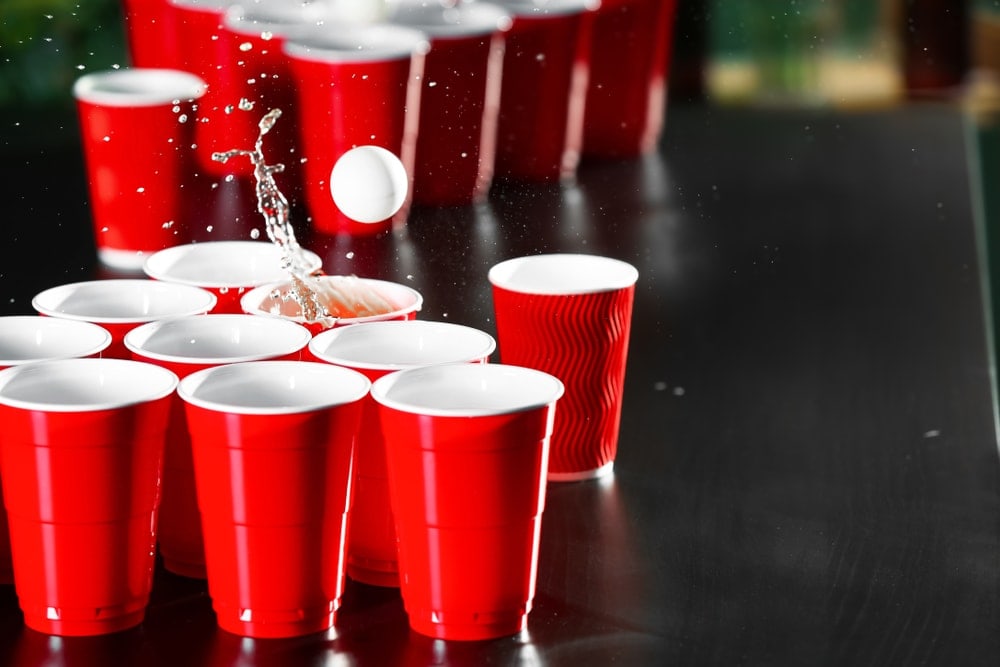 Red cups drinks and a pong ball as part of a camping game