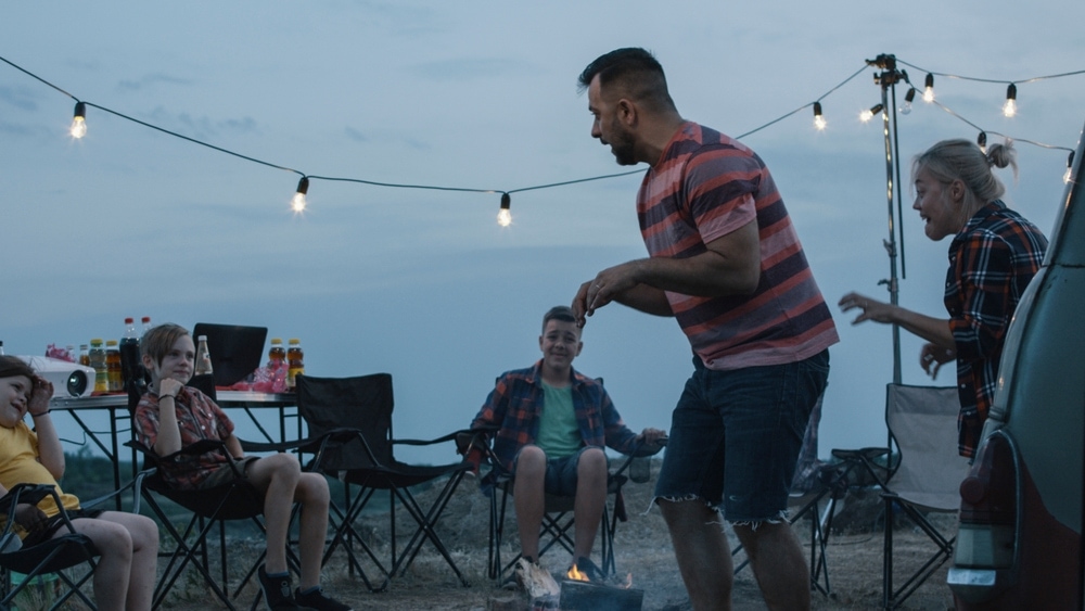 Friends playing charades over a campfire