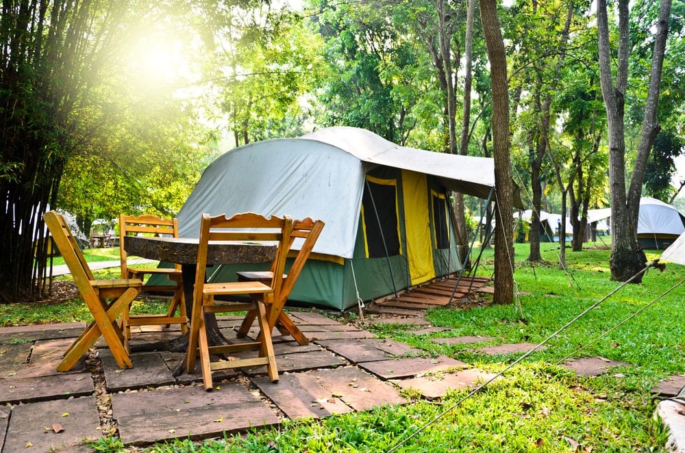Clean campsite with table and chairs beside the tent