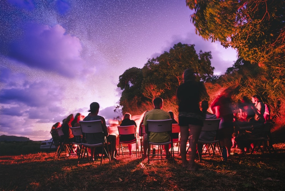 People sitting around a campfire doing a campfire game