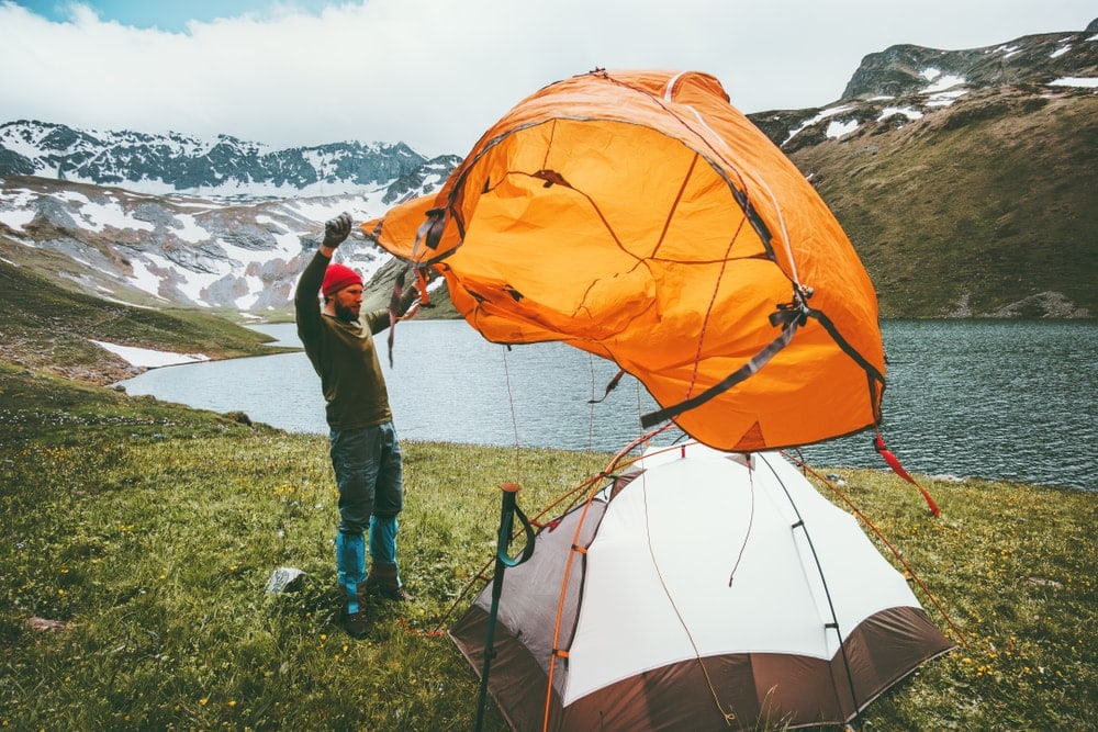Man pitching a tent during backcountry camping