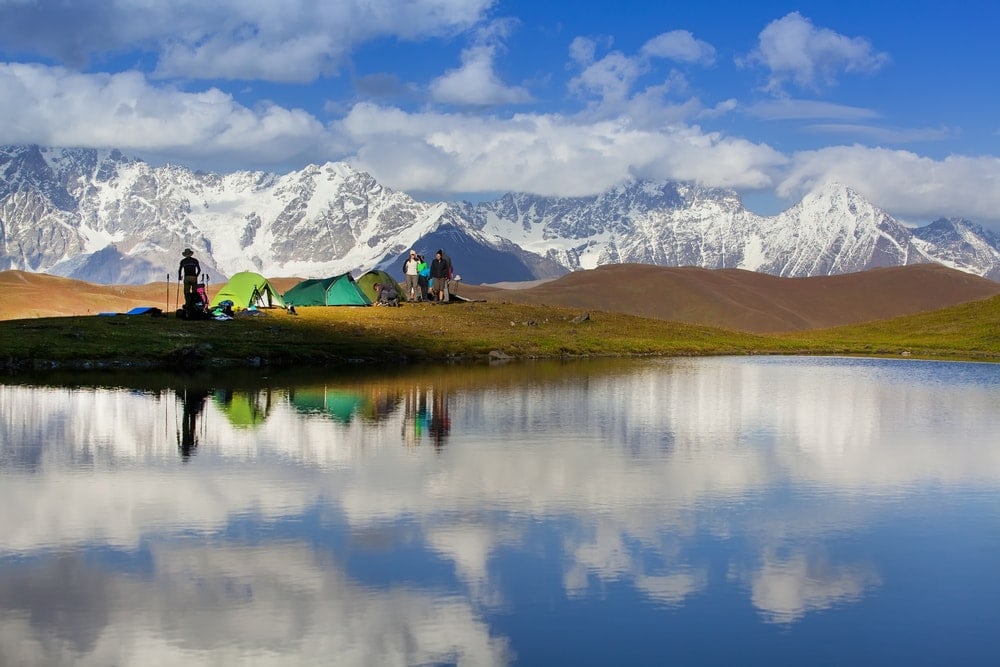 Group of people on a backcountry camping near a lake 