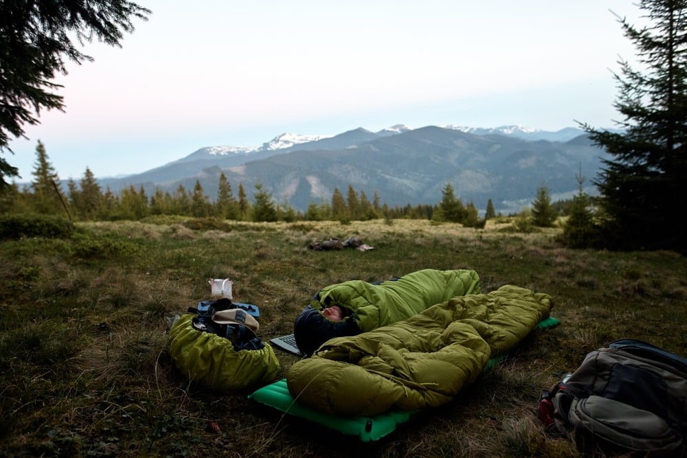 Man sleeping alone in a sleeping bag in the woods