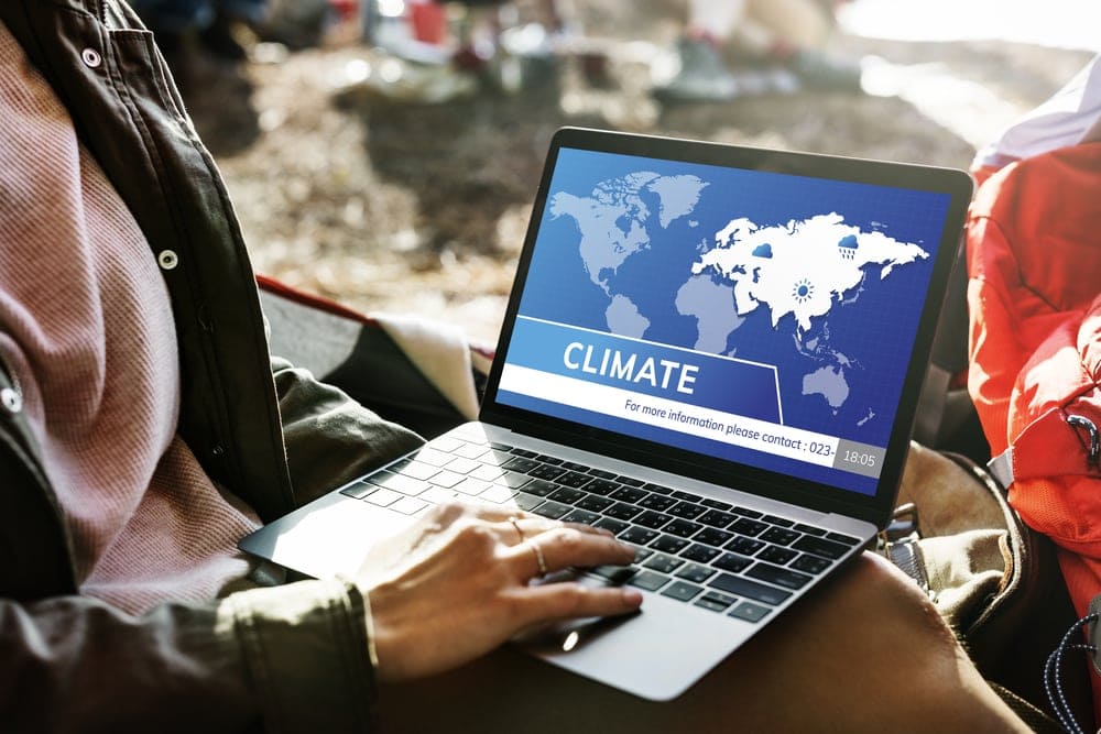 Laptop on knees while checking the weather forecast