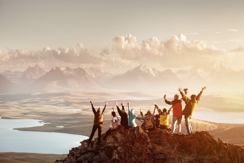 Large group of hikers enjoying the view on top of a mountain