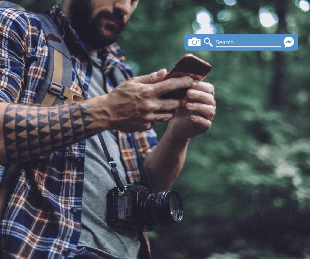 HIker holding a phone looking for a hiking buddy in facebook