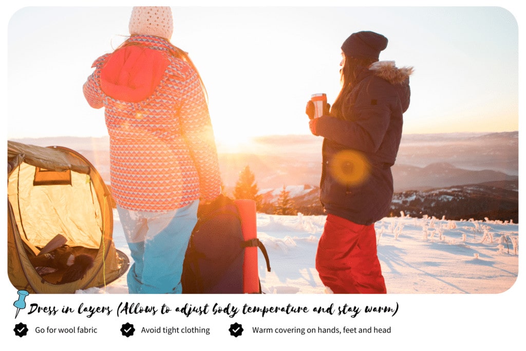 Two people dressing in layers looking at the sun in a early morning