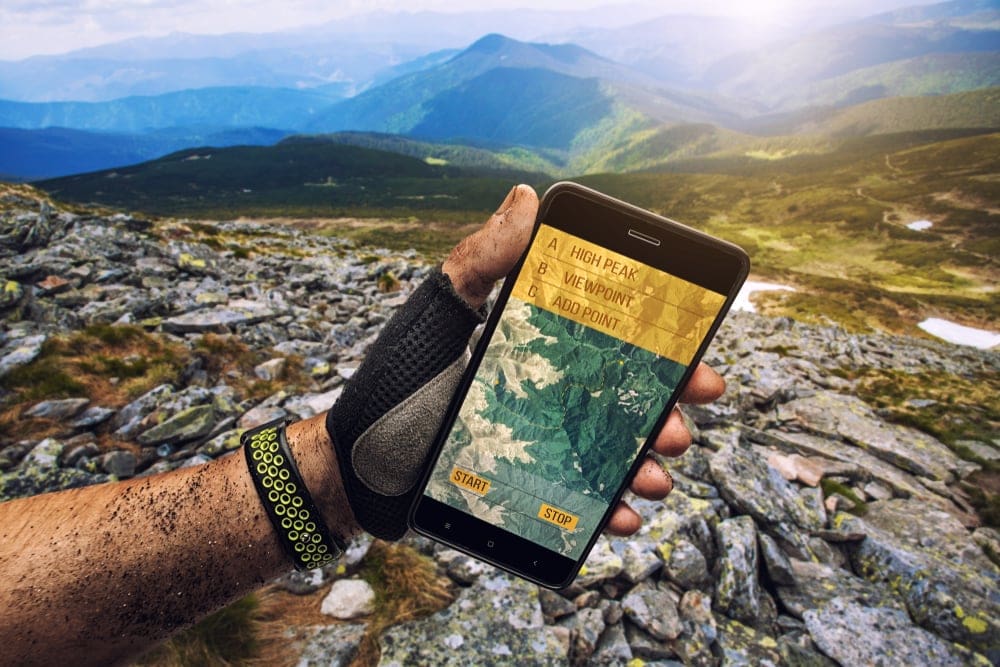 Man with gloves holding a smartphone gps for navigation 
