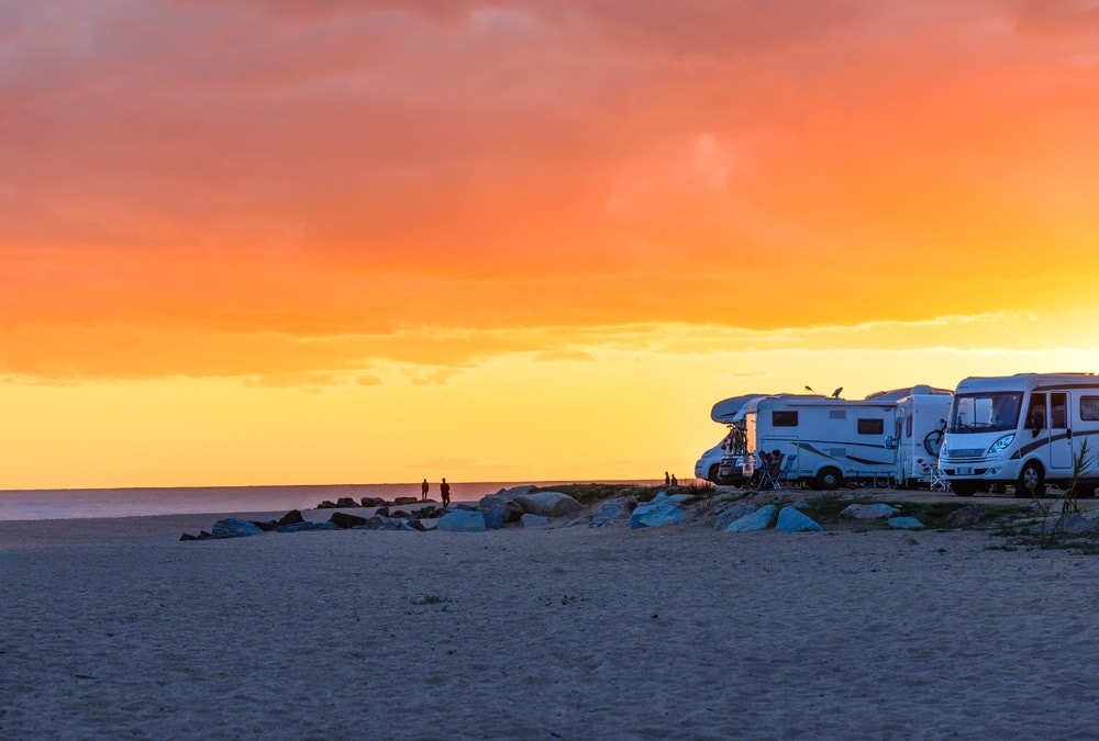 Campers on the beach during a summer sunset