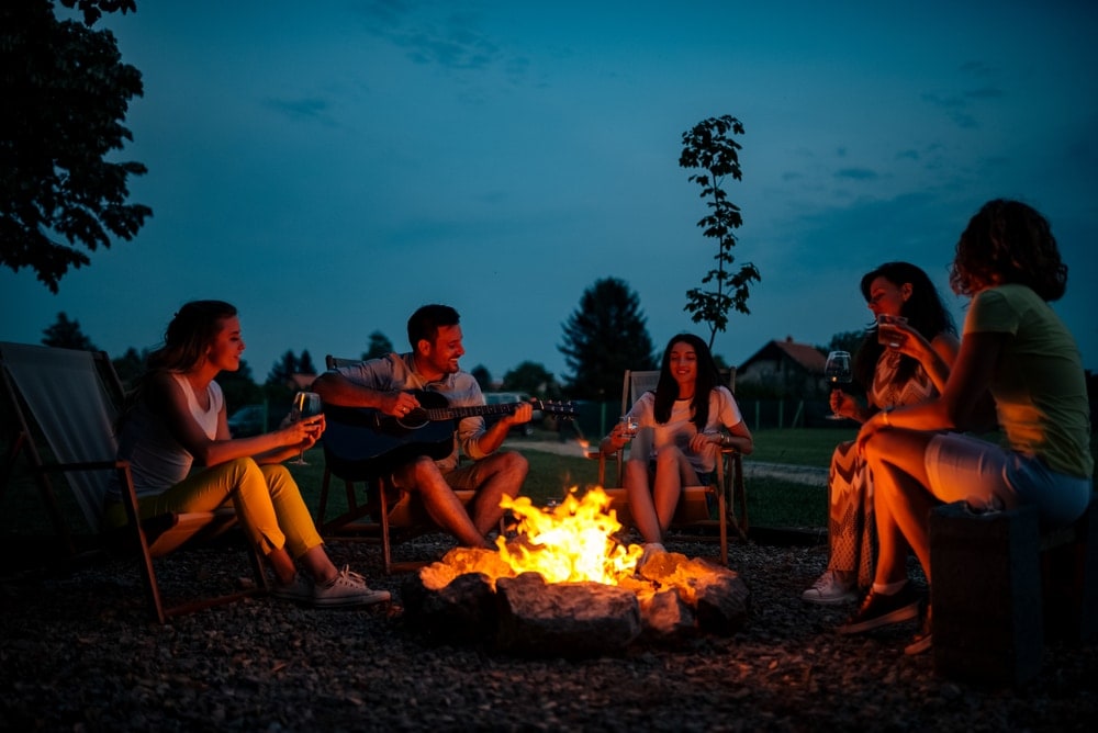 Group of friends singing around a campfire