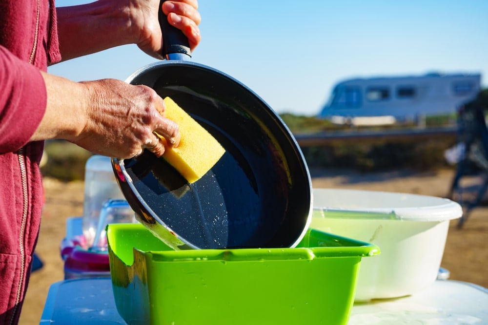 Woman washing up dishes in the campsite