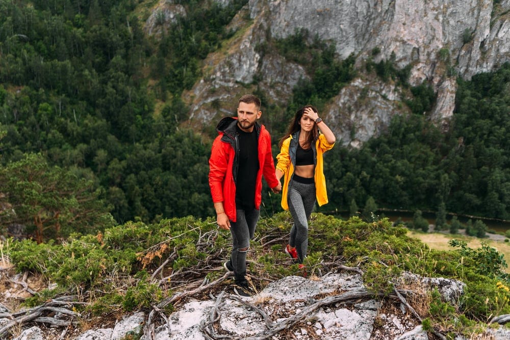 Couple are holding hands while hiking 
