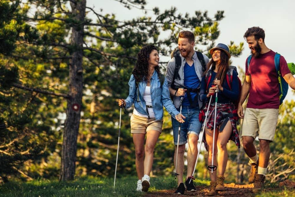 2 couples laughing while hiking on the woods