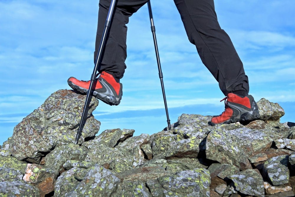 Hiking on rocks with a hiking shoes and trek poles