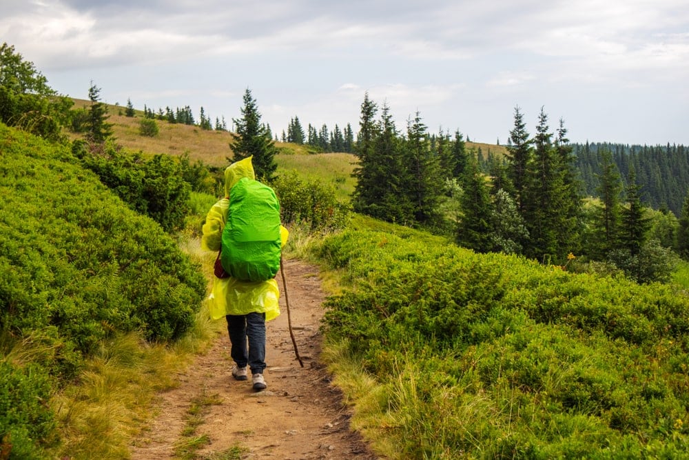 Hiker wearing a rain poncho on the trail