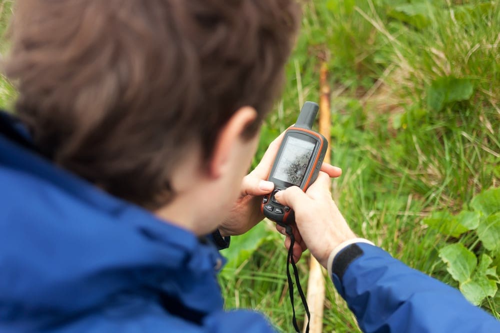 Man holding a satellite phone while hiking