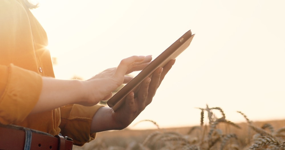 A woman holding a tablet while searching for internet while camping