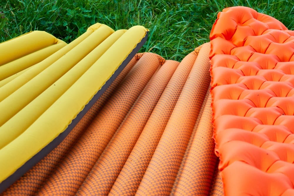 Three Inflatable camping mattresses in vibrant colors